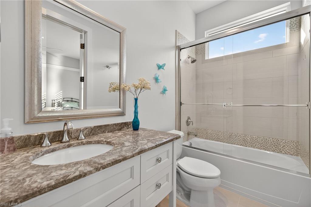 2305 Harrier Run Naples, FL 34105 - Photo 29 of 50 a bathroom with a granite countertop sink toilet and shower