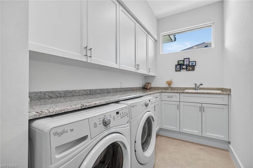 2305 Harrier Run Naples, FL 34105 - Photo 32 of 50 a utility room with granite countertop cabinets washer and dryer