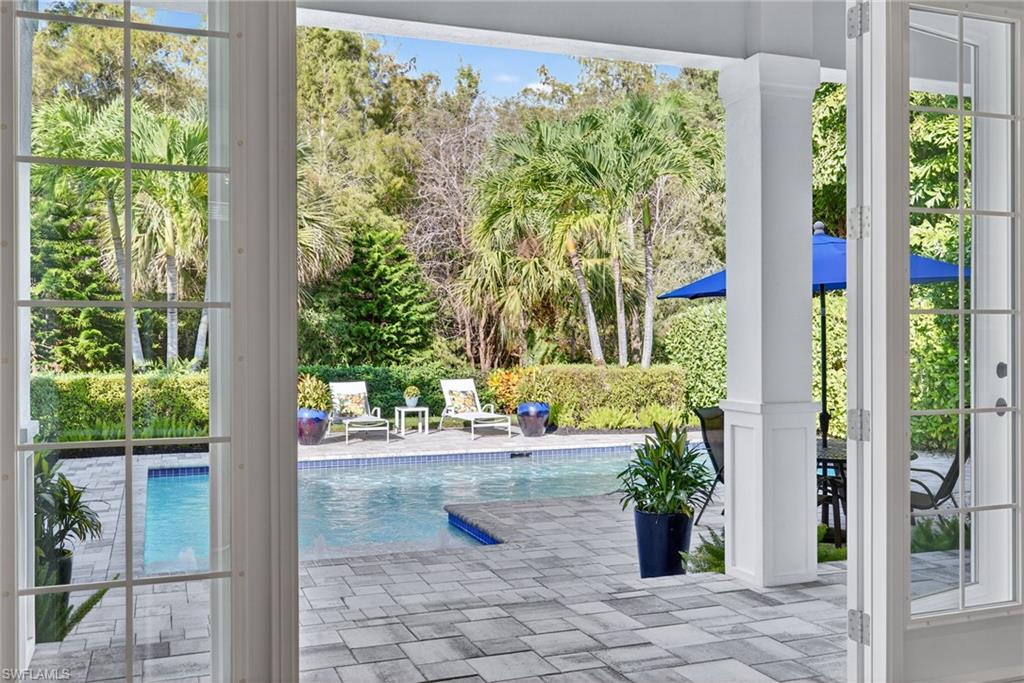 2305 Harrier Run Naples, FL 34105 - Photo 34 of 50 a view of a porch with chairs and floor to ceiling window