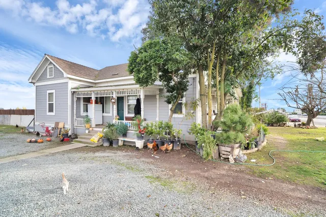 a view of a house with backyard sitting area and garden