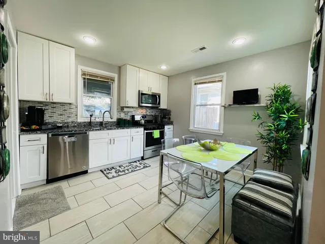 a kitchen with stainless steel appliances kitchen island granite countertop a sink a stove a microwave a counter top space and cabinets