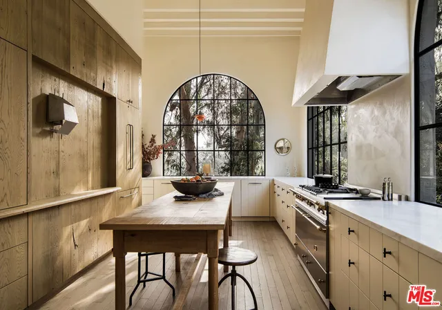 a kitchen with stainless steel appliances a stove a table and chairs in it