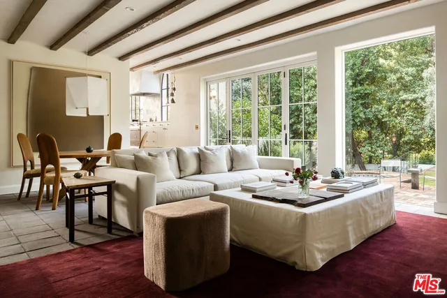 a living room with fireplace furniture and a large window
