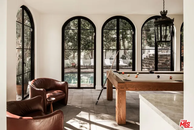 a living room with furniture and floor to ceiling windows