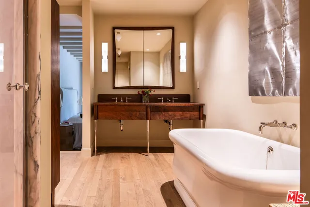 a bathroom with a bathtub sink and mirror