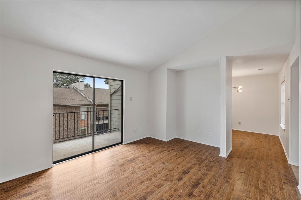 5335 Bent Tree Forest Drive, Unit 288 Dallas, TX 75248 - Photo 13 of 27 an empty room with wooden floor and windows
