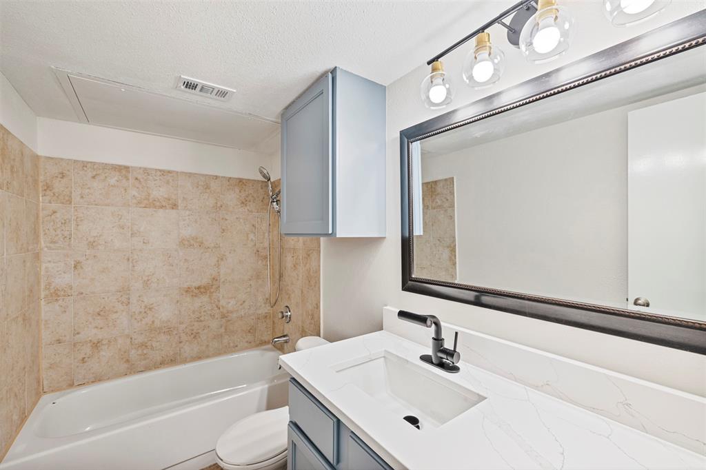 5335 Bent Tree Forest Drive, Unit 288 Dallas, TX 75248 - Photo 22 of 27 a bathroom with a sink a toilet and shower
