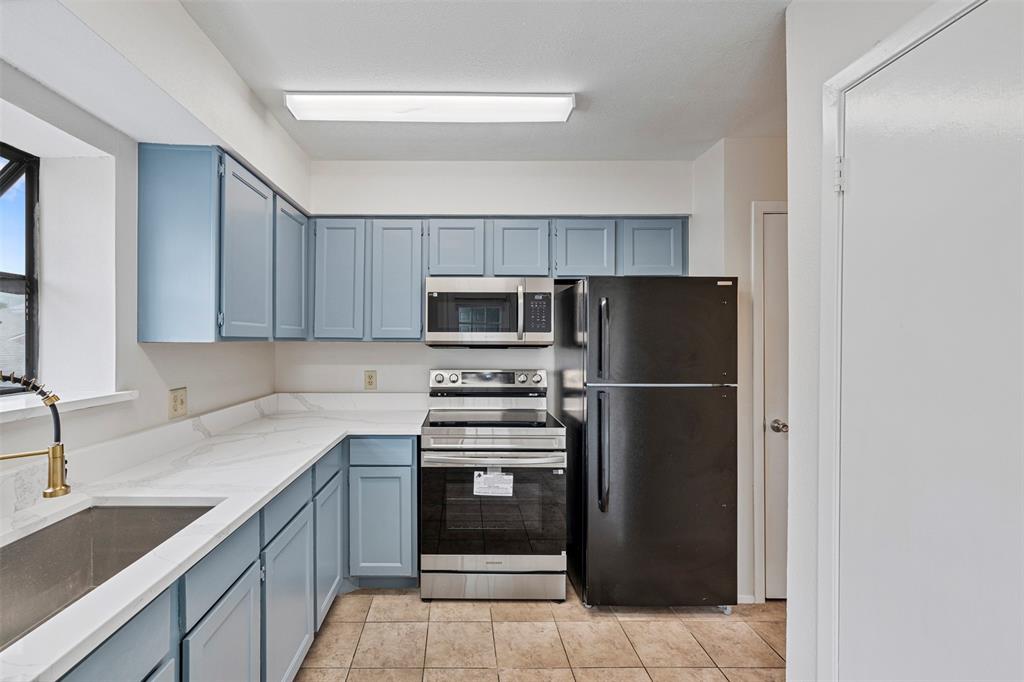 5335 Bent Tree Forest Drive, Unit 288 Dallas, TX 75248 - Photo 7 of 27 a kitchen with a refrigerator sink and cabinets