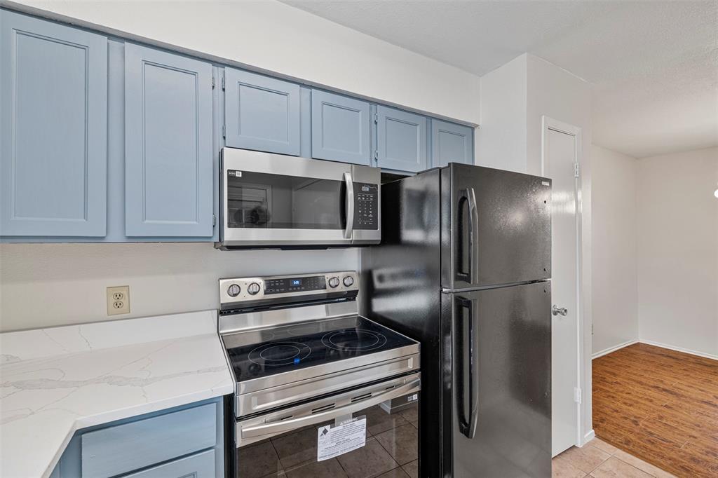 5335 Bent Tree Forest Drive, Unit 288 Dallas, TX 75248 - Photo 8 of 27 a kitchen with stainless steel appliances a refrigerator stove and microwave