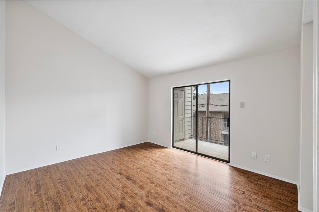 5335 Bent Tree Forest Drive, Unit 288 Dallas, TX 75248 - Photo 10 of 27 an empty room with wooden floor and sliding door