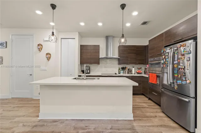a kitchen with stainless steel appliances granite countertop a sink a stove and a refrigerator