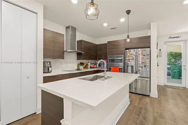 a kitchen with kitchen island a sink appliances and a counter top space