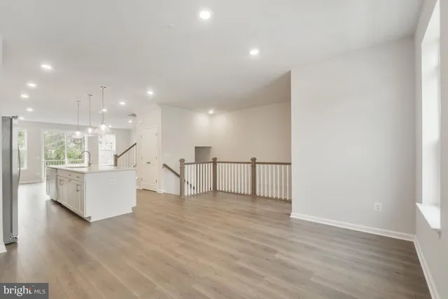 a view of an empty room with wooden floor and windows