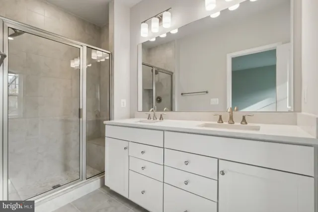 a bathroom with double sink shower and a mirror