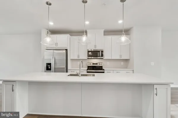 a kitchen with stainless steel appliances a refrigerator a stove a sink and a oven