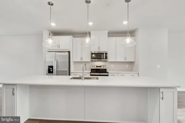 a kitchen with stainless steel appliances a refrigerator a stove a sink and a oven