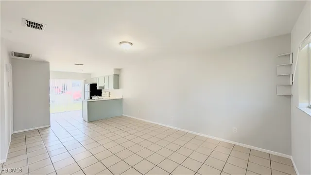 a view of kitchen with refrigerator cabinets and window