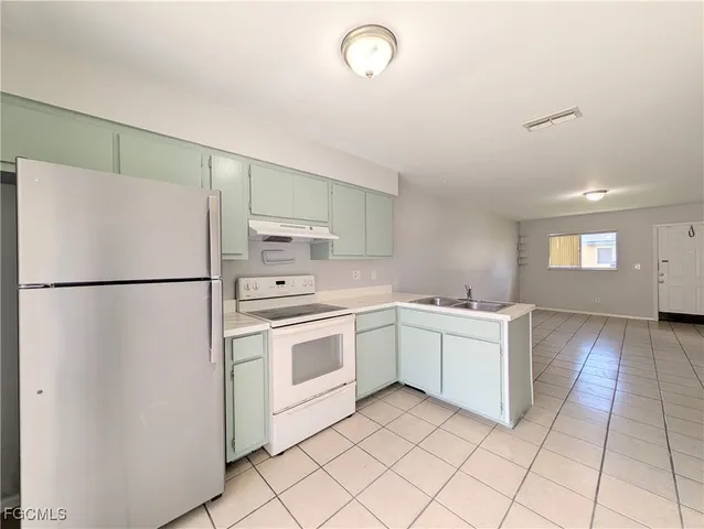 a kitchen with white cabinets and white appliances