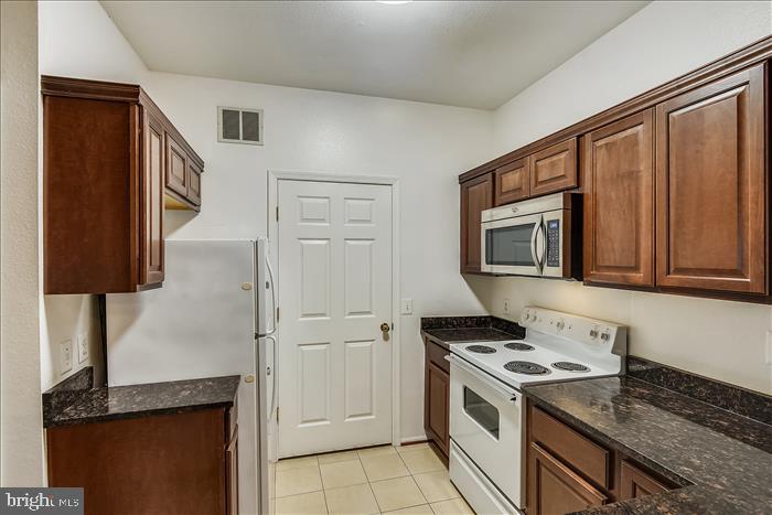 1601 Spring Gate Dr., Unit 1110 McLean, VA 22102 - Photo 14 of 26 a kitchen with stainless steel appliances granite countertop a stove a sink and a refrigerator