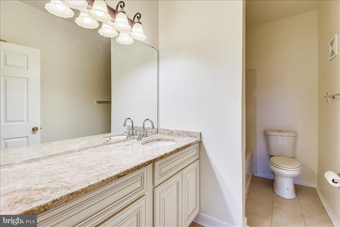 1601 Spring Gate Dr., Unit 1110 McLean, VA 22102 - Photo 19 of 26 a bathroom with a granite countertop sink a toilet and a mirror