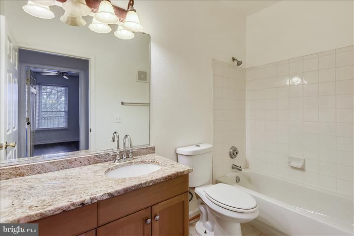 1601 Spring Gate Dr., Unit 1110 McLean, VA 22102 - Photo 23 of 26 a bathroom with a granite countertop sink a toilet and shower