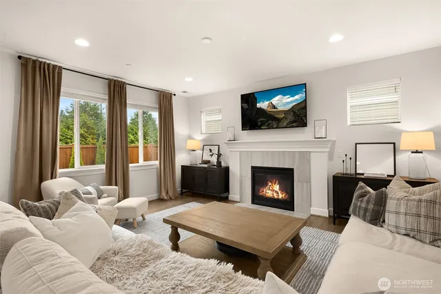 a living room with furniture a flat screen tv and a fireplace