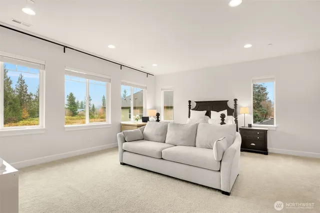 a spacious bedroom with a bed and glass walk in closet