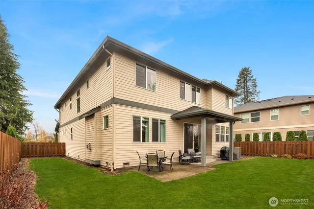 a view of a backyard with table and chairs with wooden fence