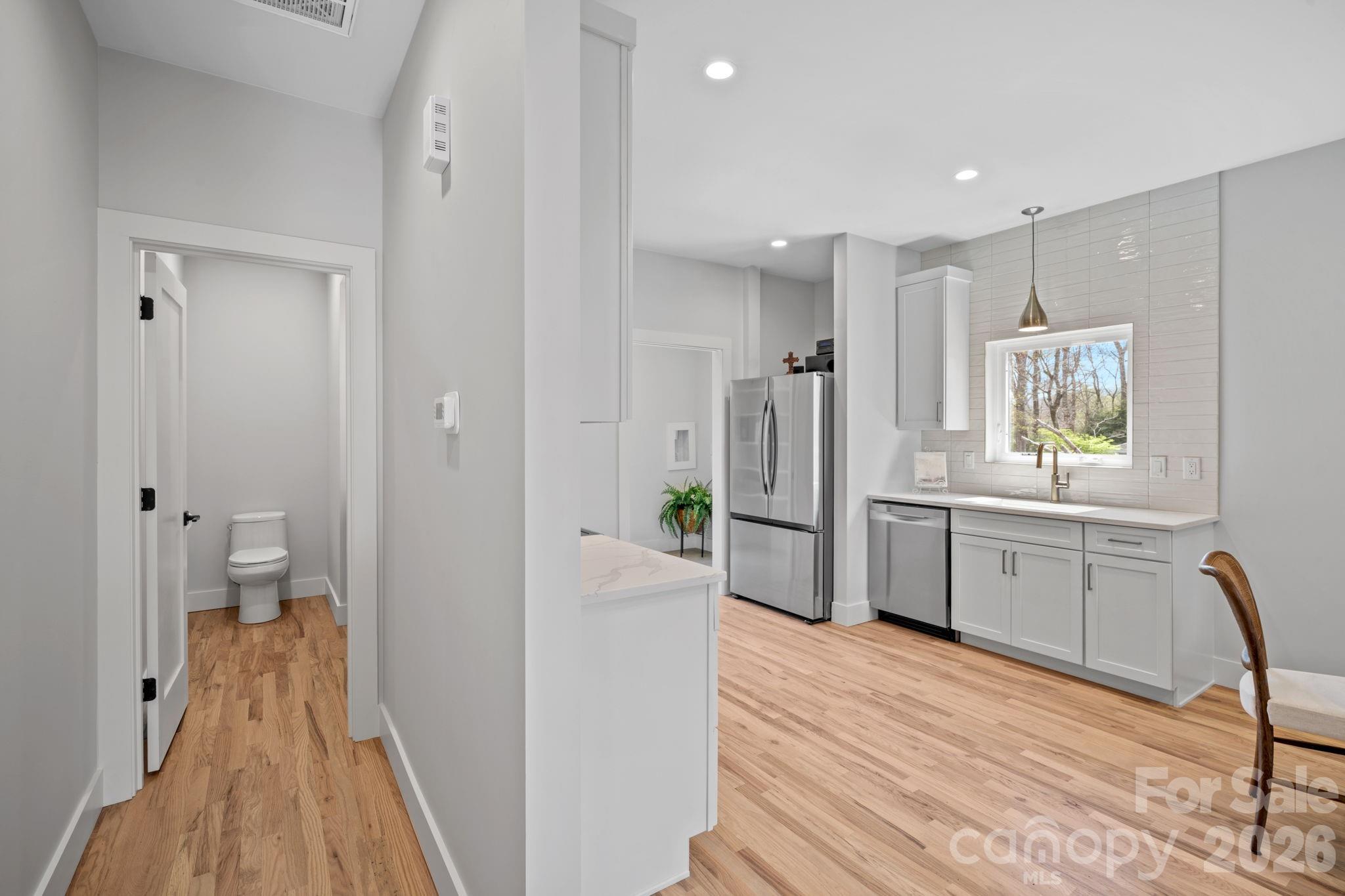 9 Gudger Road Asheville, NC 28715 - Photo 17 of 43 a kitchen with white cabinets and wooden flooring