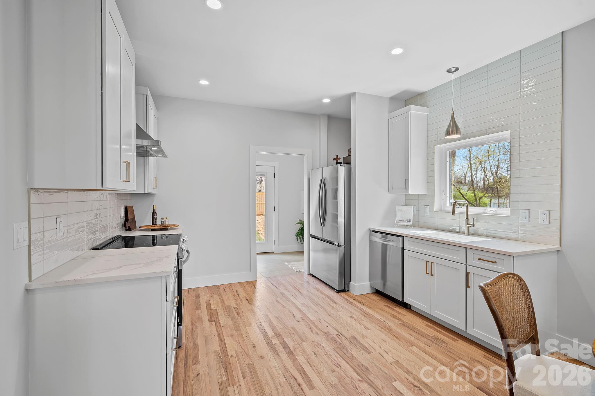 9 Gudger Road Asheville, NC 28715 - Photo 10 of 43 a kitchen with white cabinets and stainless steel appliances