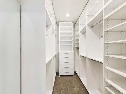 a view of walk in closet with empty racks
