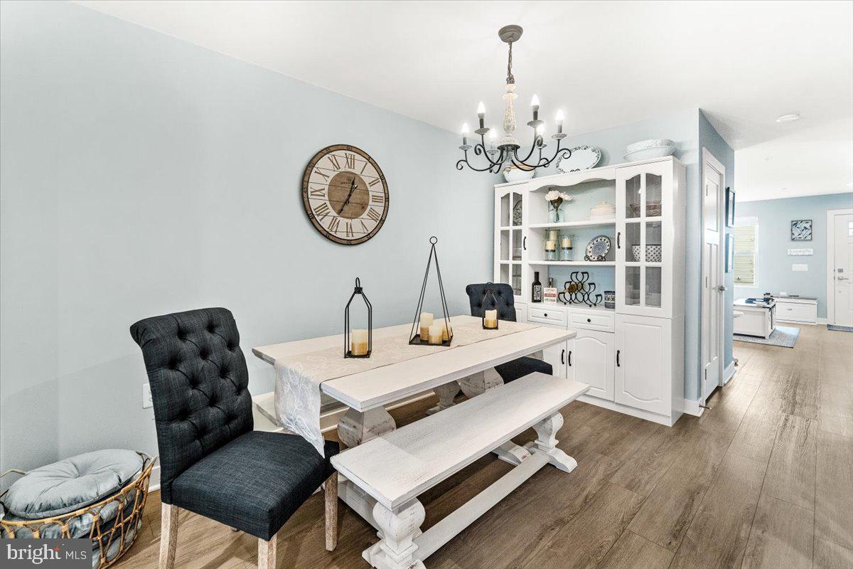 312 Hammersmith Circle Frederick, MD 21702 - Photo 6 of 41 a view of a dining room with furniture a chandelier and wooden floor