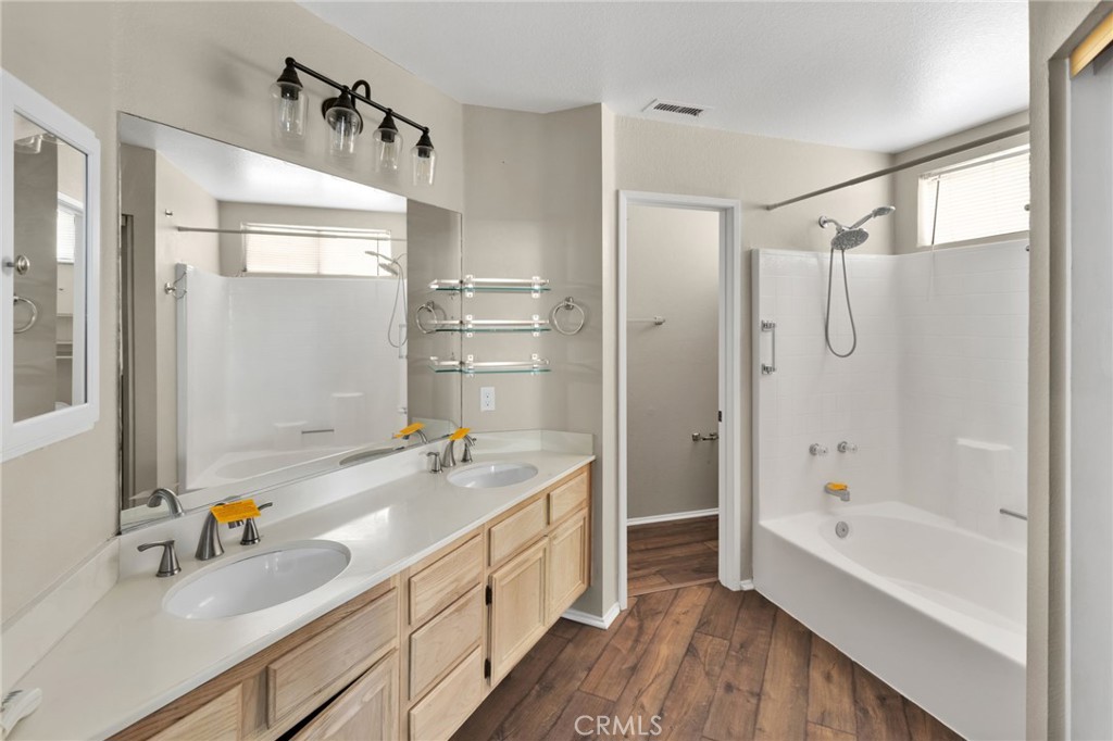 40243 Mimulus Way Temecula, CA 92591 - Photo 17 of 33 a bathroom with a tub a sink and a large mirror