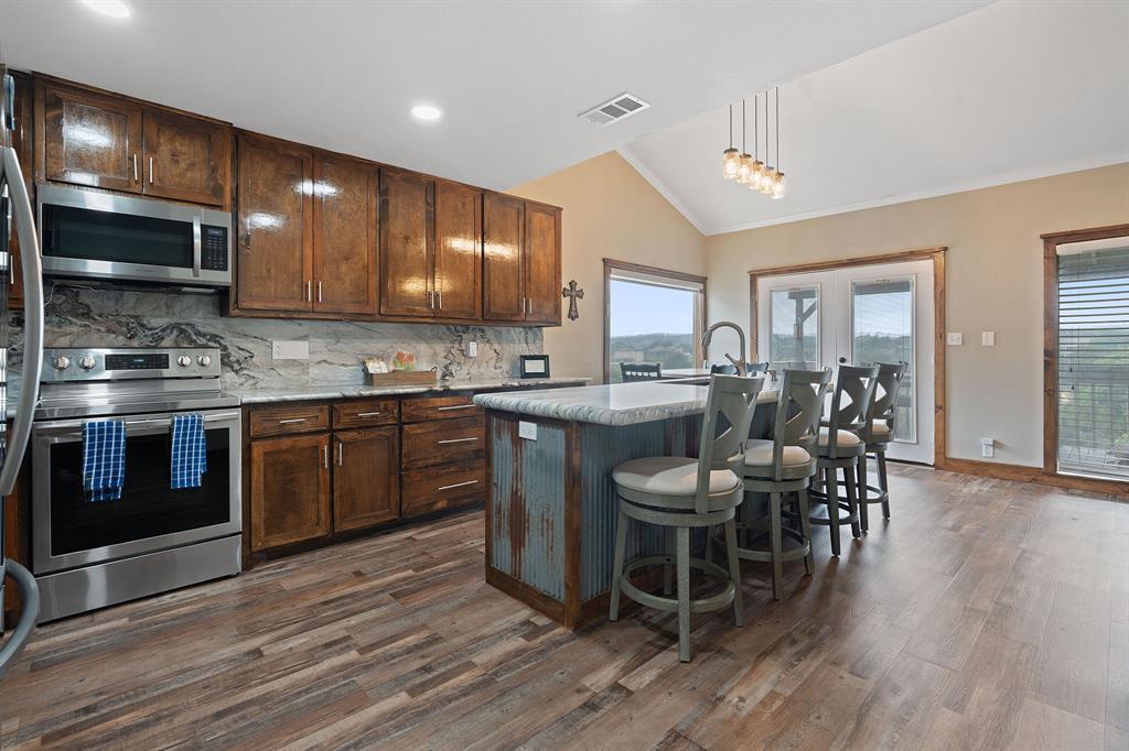 321 Venture Boulevard South Leander, TX 78645 - Photo 2 of 23 Kitchen featuring stainless steel appliances, backsplash, pendant lighting, lofted ceiling, and a kitchen bar