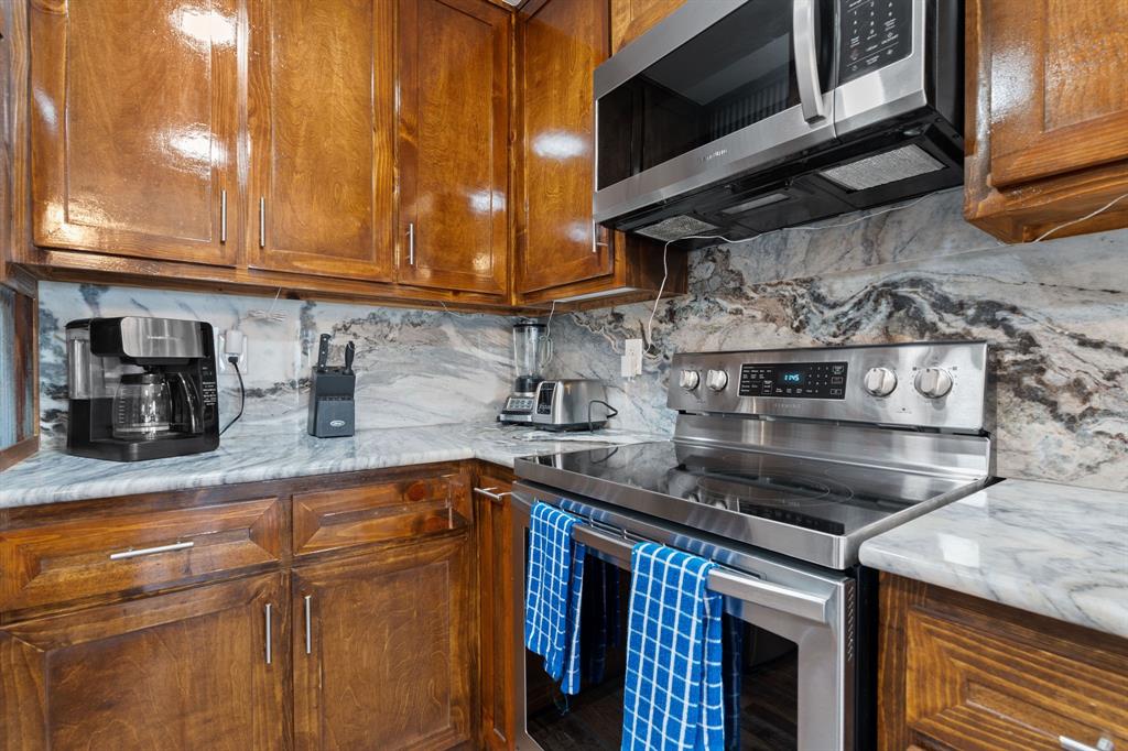 321 Venture Boulevard South Leander, TX 78645 - Photo 5 of 23 Kitchen featuring stainless steel appliances, wood finish cabinets, tasteful backsplash, and light stone counters