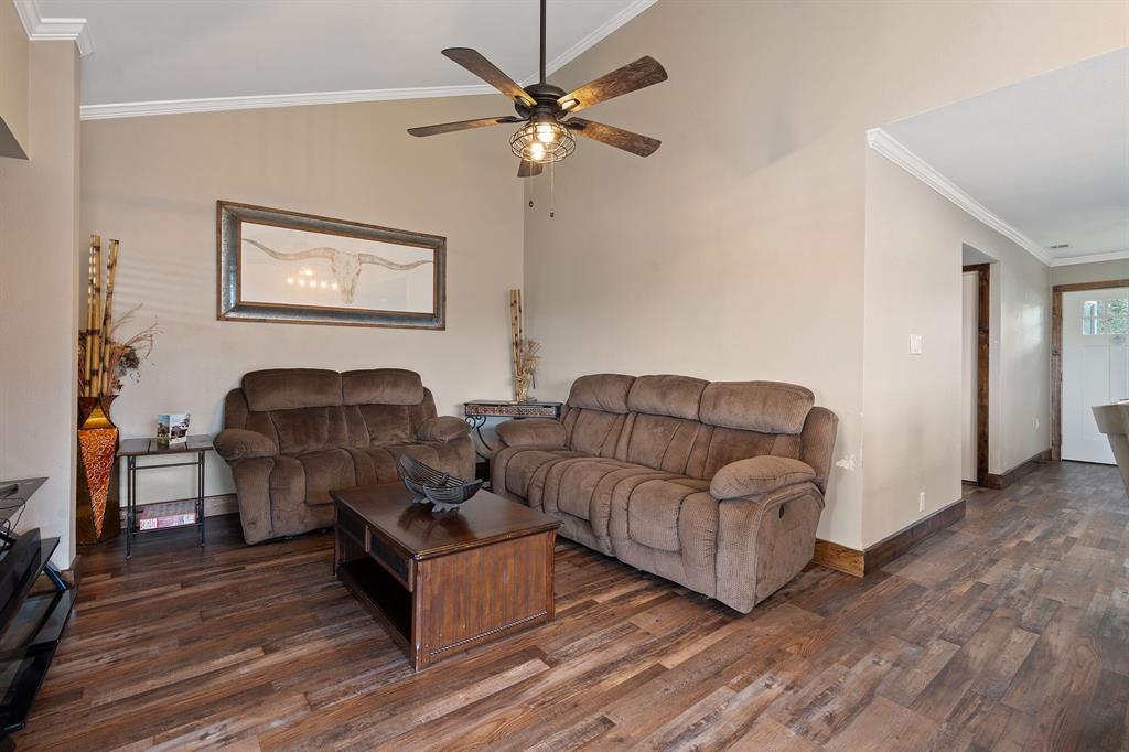 321 Venture Boulevard South Leander, TX 78645 - Photo 6 of 23 Living area featuring crown molding, vaulted ceiling, a ceiling fan, and dark wood-type flooring