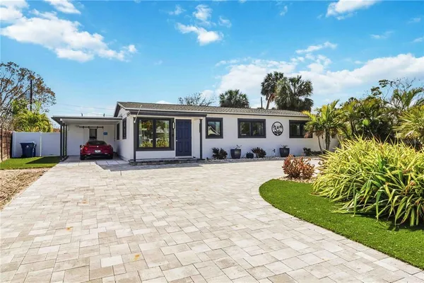 a view of a house with backyard and sitting area