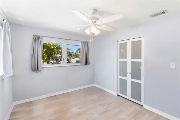 an empty room with a window and a fan
