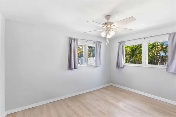 an empty room with windows and fan