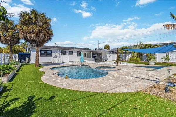 a view of swimming pool with outdoor seating and yard in back