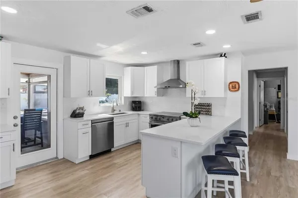 a kitchen with a sink a stove a refrigerator and white cabinets
