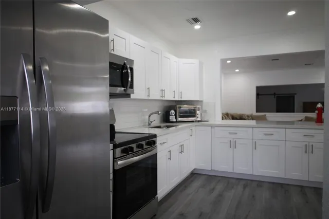 a kitchen with cabinets and stainless steel appliances