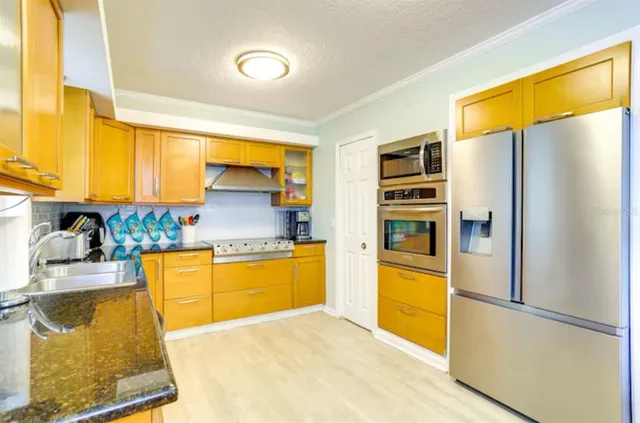 a kitchen with stainless steel appliances granite countertop a refrigerator and a stove