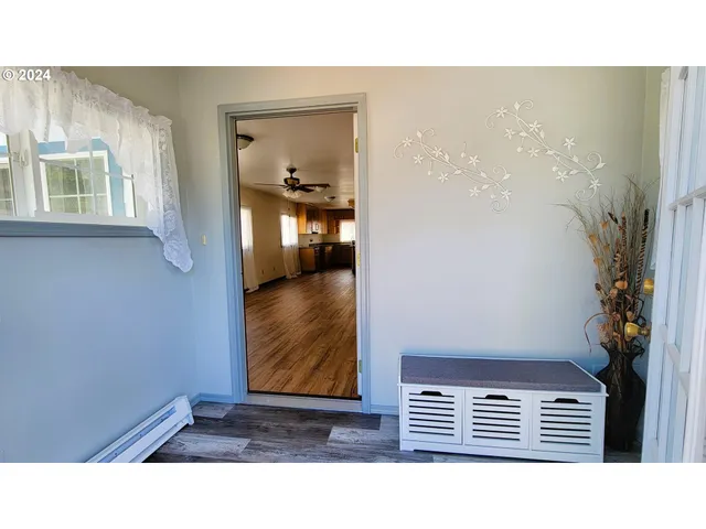 a kitchen with stainless steel appliances granite countertop a refrigerator a sink dishwasher a stove and a dining table with wooden floor