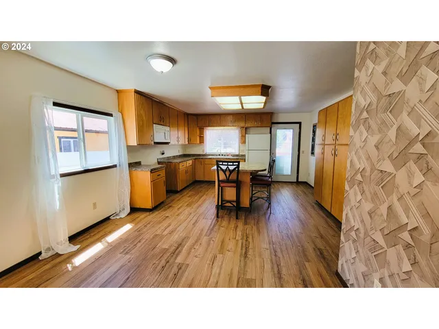 a kitchen with kitchen island a stove a sink a dining table and chairs