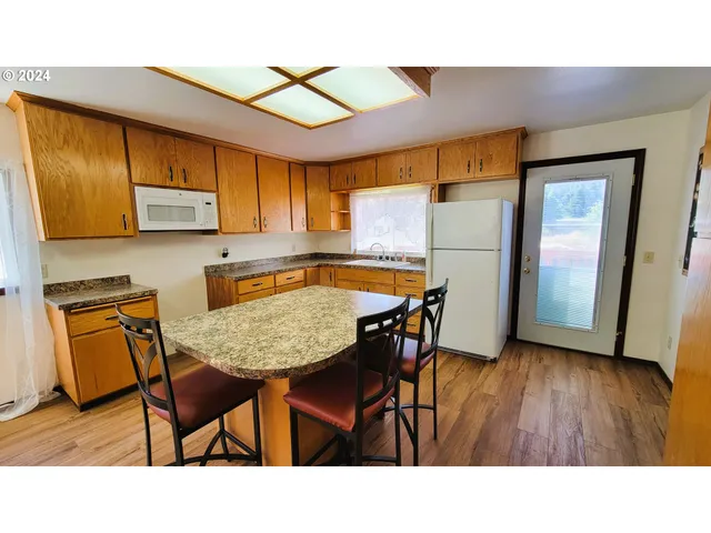 a kitchen with stainless steel appliances kitchen island granite countertop wooden floor