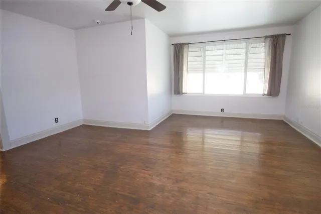 a view of a livingroom with wooden floor and a ceiling fan