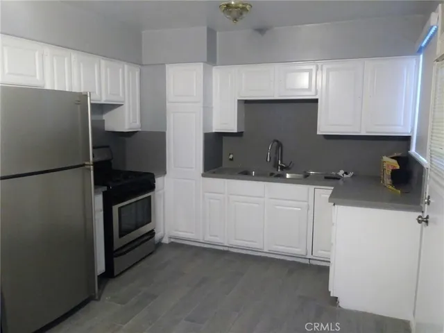 a kitchen with a refrigerator sink and cabinets