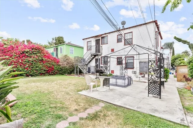 a view of a house with backyard and sitting area