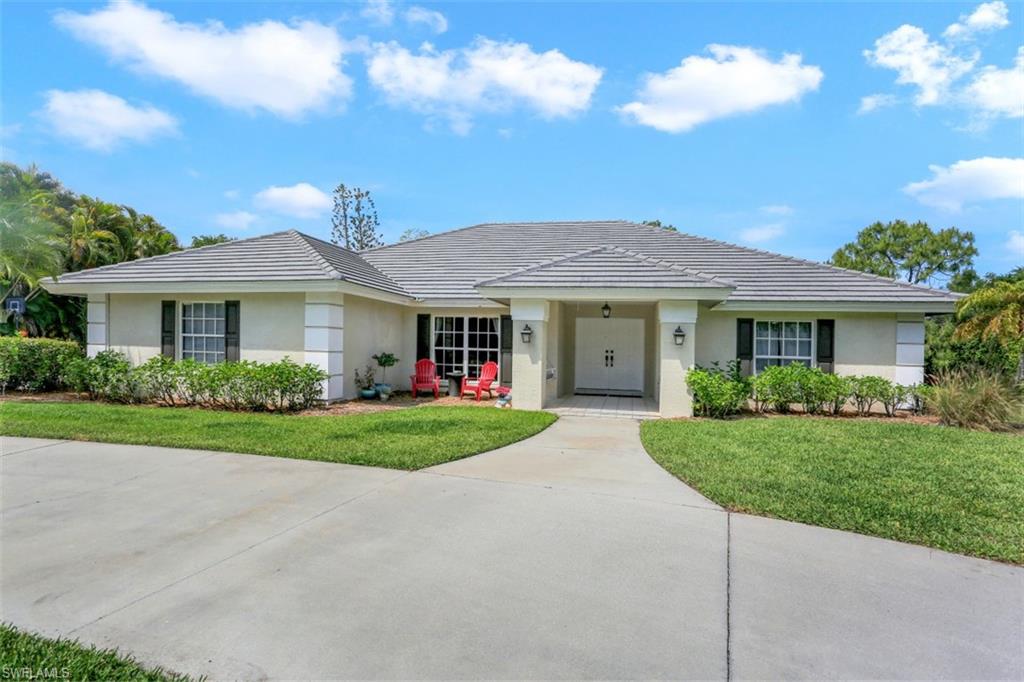 7359 Stonegate Drive Naples, FL 34109 - Photo 1 of 33 a front view of a house with a yard